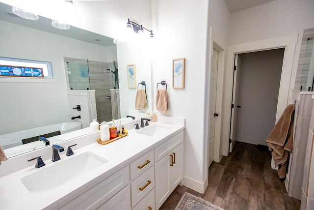 bathroom with wood-type flooring, shower with separate bathtub, and vanity