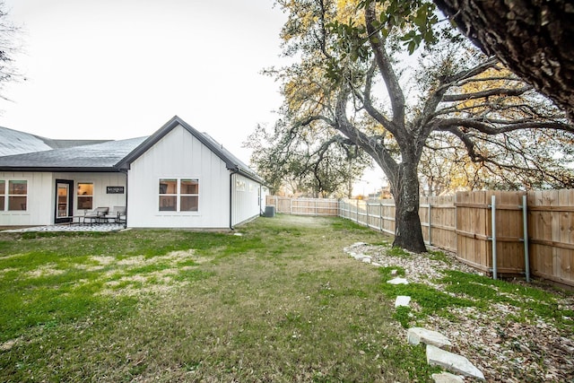 view of yard with a patio area, a fenced backyard, and central AC