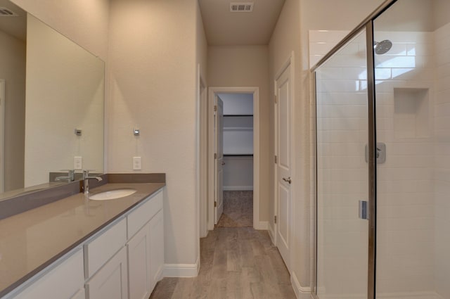 bathroom featuring vanity, an enclosed shower, and wood-type flooring