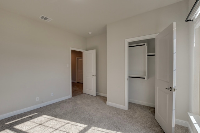 unfurnished bedroom featuring light carpet and a closet