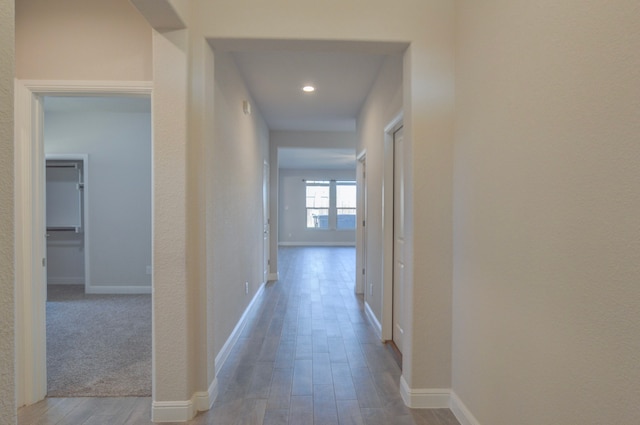 corridor with hardwood / wood-style flooring