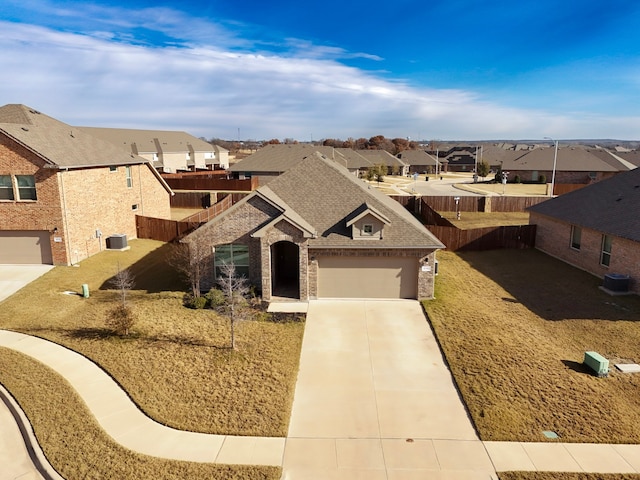 view of front of house with central AC, a front lawn, and a garage