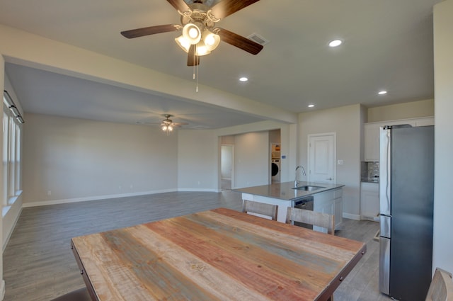 dining room featuring ceiling fan, light hardwood / wood-style floors, sink, and washer / clothes dryer