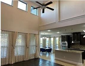 kitchen featuring a high ceiling, backsplash, wall oven, and ceiling fan