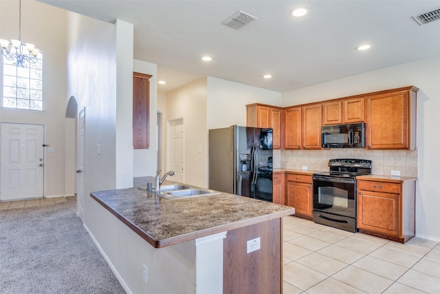 kitchen with sink, kitchen peninsula, a chandelier, light carpet, and black appliances