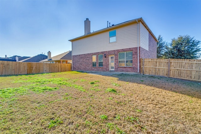 back of house with a lawn