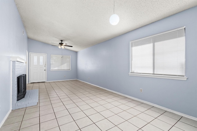 unfurnished living room with a textured ceiling, ceiling fan, lofted ceiling, and light tile patterned flooring