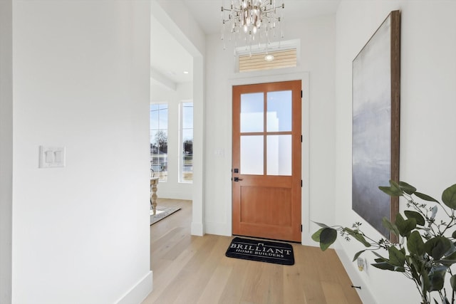 doorway with light hardwood / wood-style flooring and an inviting chandelier