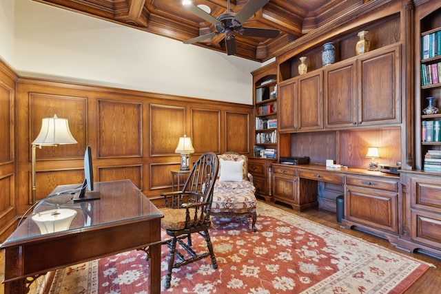 office featuring beam ceiling, coffered ceiling, crown molding, wood walls, and built in desk