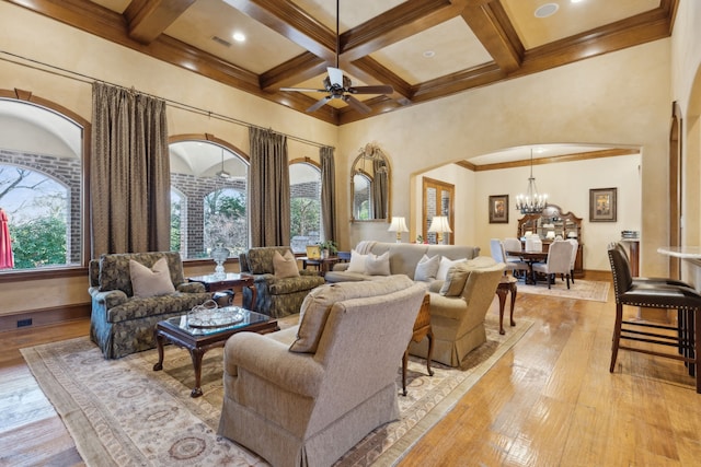 living room featuring coffered ceiling, ceiling fan with notable chandelier, light hardwood / wood-style flooring, ornamental molding, and beam ceiling