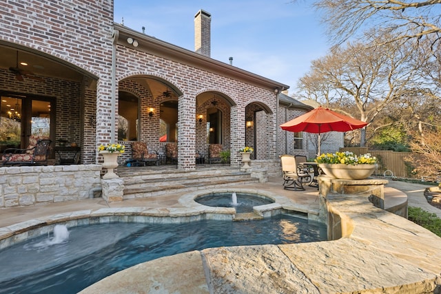 view of pool featuring an in ground hot tub and a patio