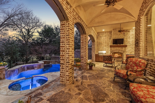 view of patio / terrace featuring ceiling fan, a swimming pool with hot tub, and an outdoor brick fireplace