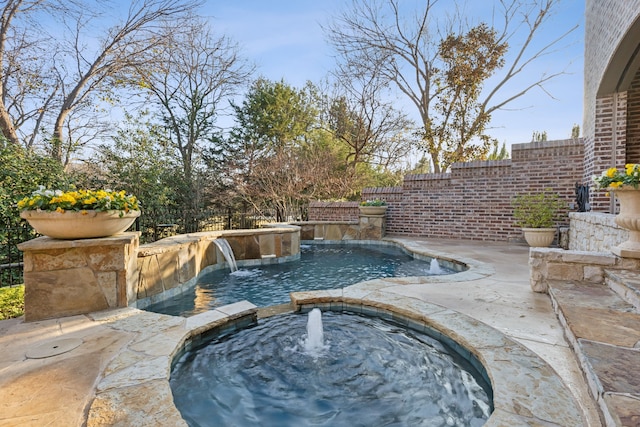 view of pool featuring pool water feature and an in ground hot tub