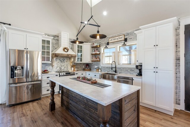 kitchen with white cabinetry, a center island, sink, and stove