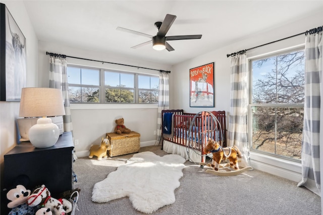 carpeted bedroom featuring multiple windows and ceiling fan