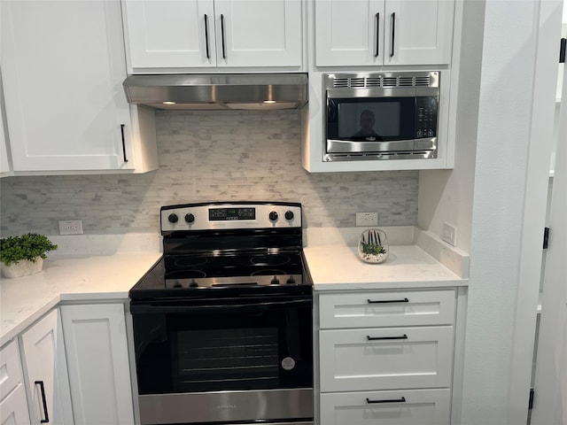 kitchen with tasteful backsplash, white cabinetry, exhaust hood, and appliances with stainless steel finishes