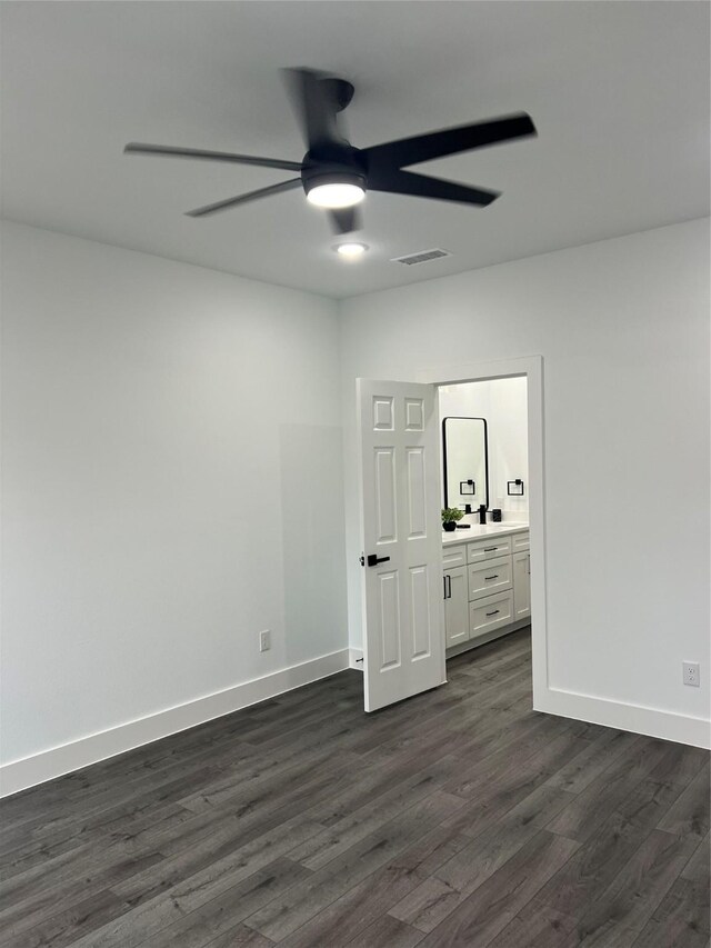 unfurnished bedroom with ensuite bath, ceiling fan, and dark hardwood / wood-style flooring