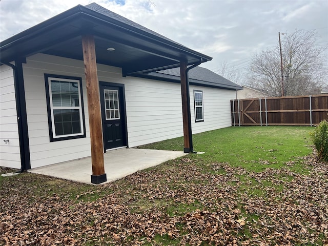 rear view of house featuring a lawn and a patio