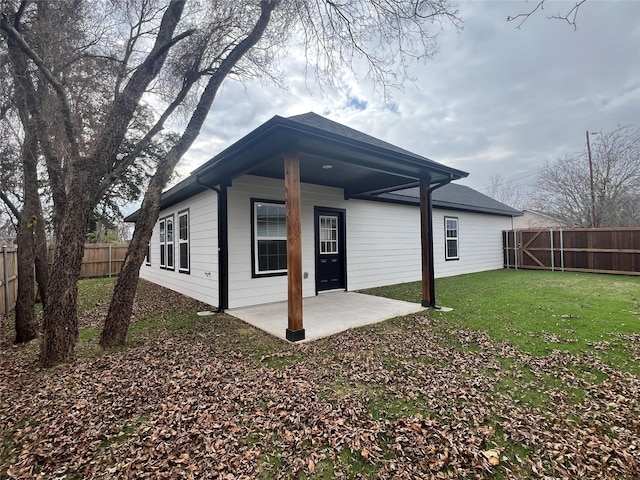 rear view of property with a lawn and a patio