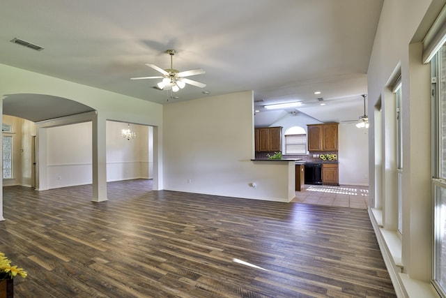 unfurnished living room with ceiling fan with notable chandelier, dark hardwood / wood-style floors, and lofted ceiling