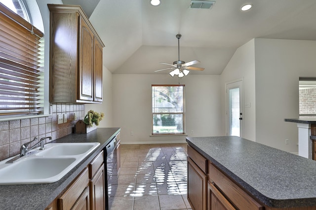 kitchen with a center island, lofted ceiling, sink, tasteful backsplash, and light tile patterned flooring