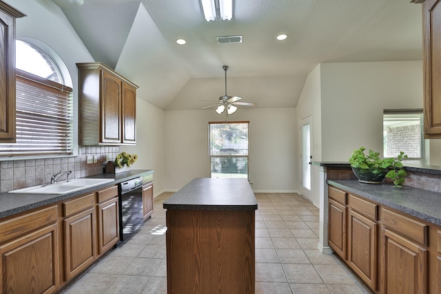 kitchen featuring sink, a kitchen island, vaulted ceiling, and light tile patterned floors