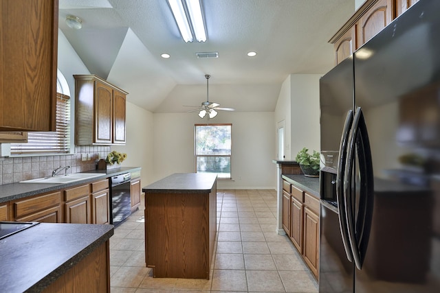 kitchen featuring a center island, sink, backsplash, vaulted ceiling, and black appliances