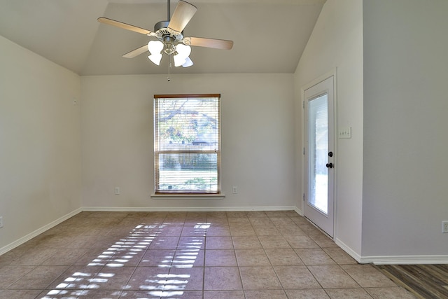 empty room featuring ceiling fan, light tile patterned floors, and vaulted ceiling