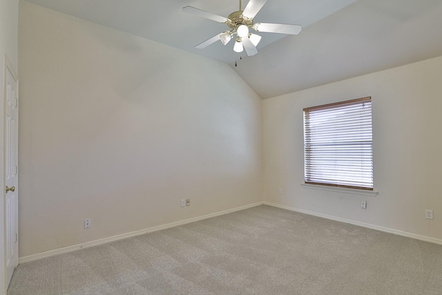 spare room featuring ceiling fan, light colored carpet, and vaulted ceiling