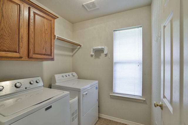 clothes washing area with plenty of natural light, cabinets, independent washer and dryer, and light tile patterned floors