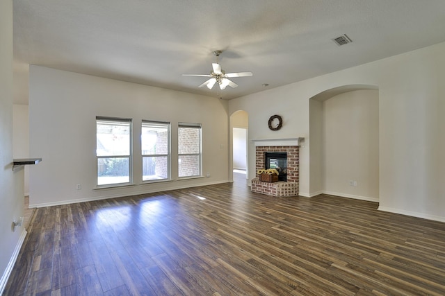 unfurnished living room featuring ceiling fan, a fireplace, and dark hardwood / wood-style floors