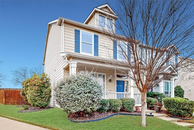 view of property featuring a porch and a front lawn