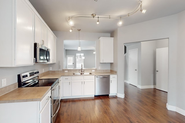 kitchen featuring sink, dark hardwood / wood-style flooring, decorative light fixtures, white cabinets, and appliances with stainless steel finishes