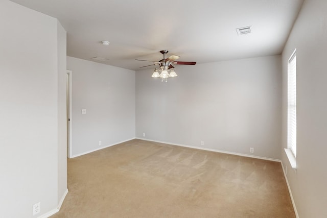 spare room with ceiling fan and light colored carpet