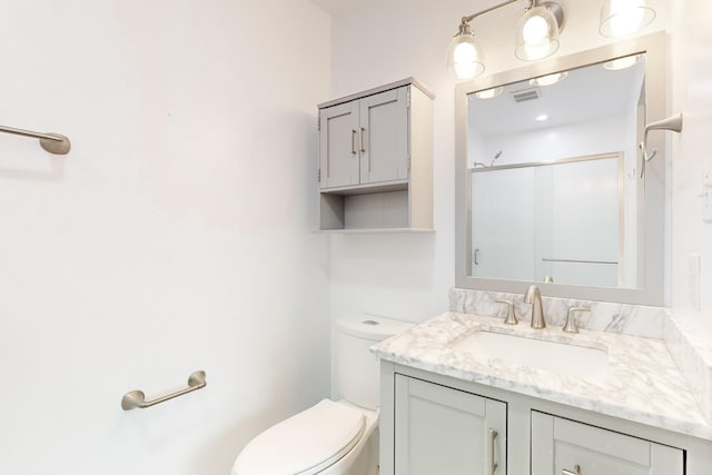 bathroom featuring vanity, toilet, and an enclosed shower