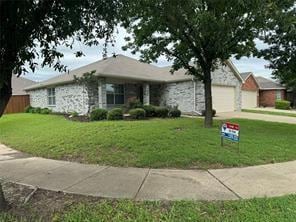 ranch-style house featuring a garage and a front lawn