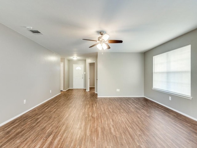 empty room with hardwood / wood-style floors and ceiling fan