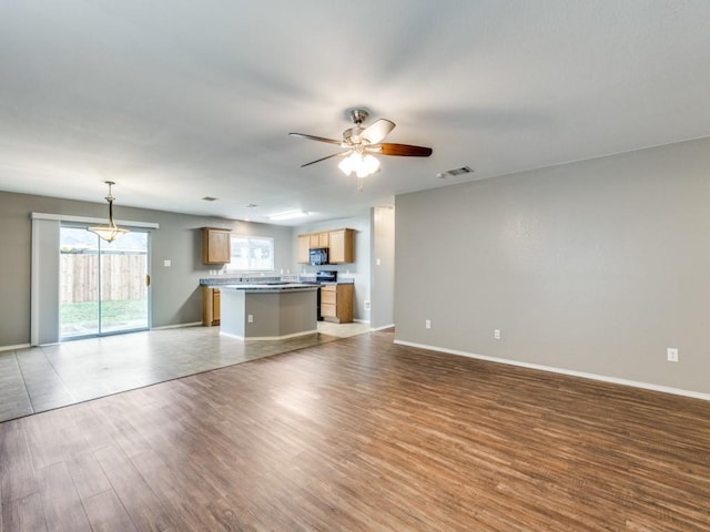 unfurnished living room with ceiling fan and light hardwood / wood-style floors