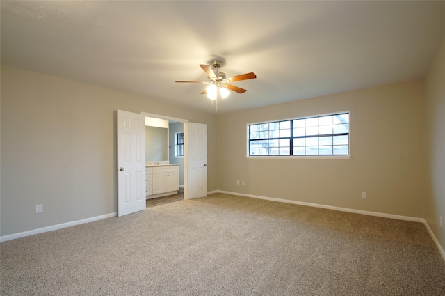 unfurnished bedroom featuring carpet, ceiling fan, and ensuite bathroom