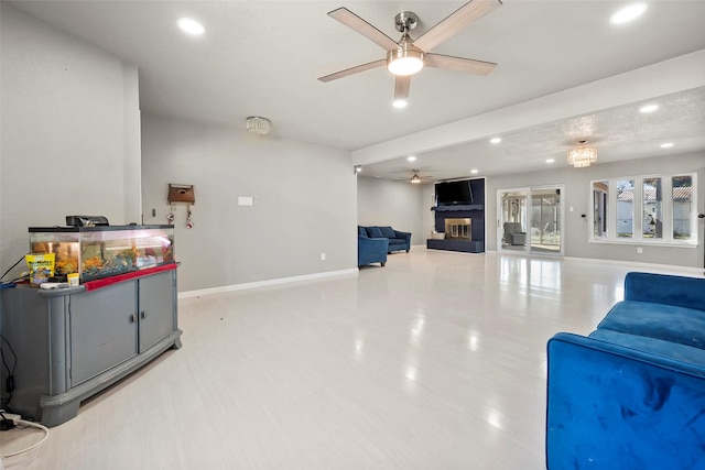 living room featuring a multi sided fireplace and ceiling fan