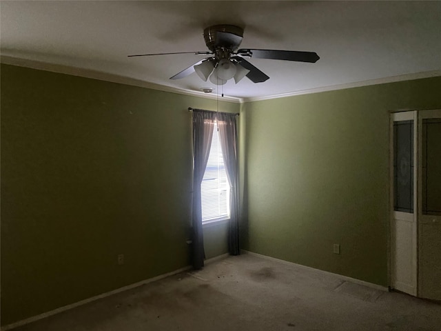 carpeted spare room featuring ceiling fan and ornamental molding