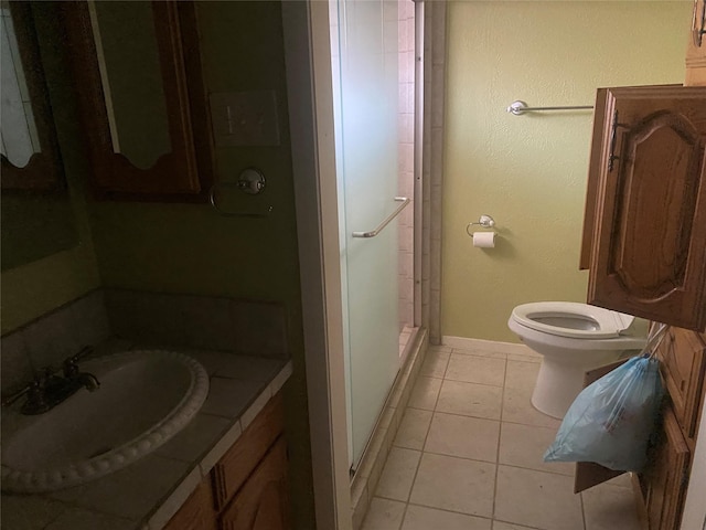 bathroom featuring tile patterned floors, vanity, toilet, and a shower with door