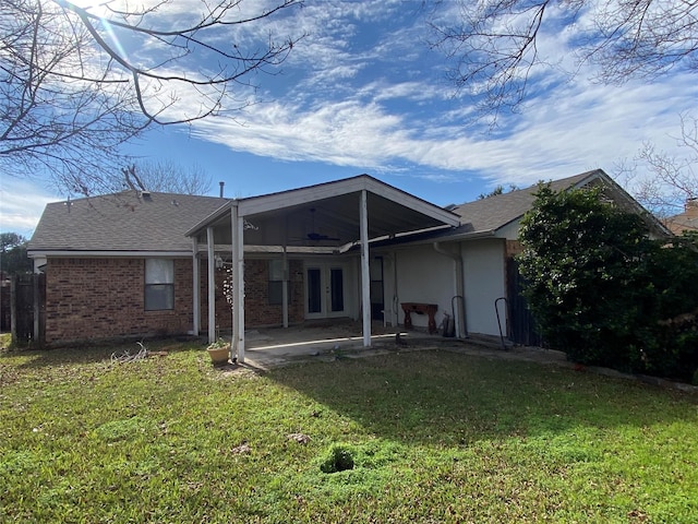 rear view of property with ceiling fan, a patio area, and a lawn