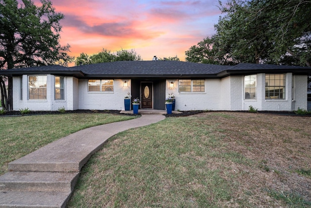 ranch-style home with a lawn