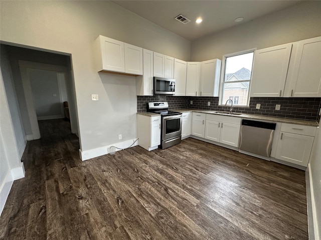 kitchen with white cabinetry, appliances with stainless steel finishes, and dark wood-type flooring