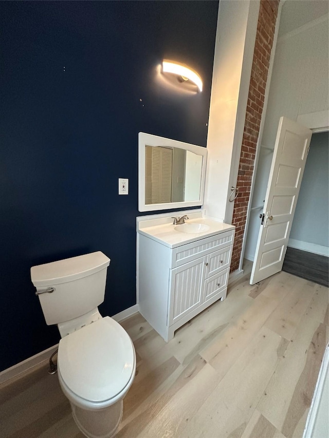 bathroom featuring wood-type flooring, vanity, and toilet