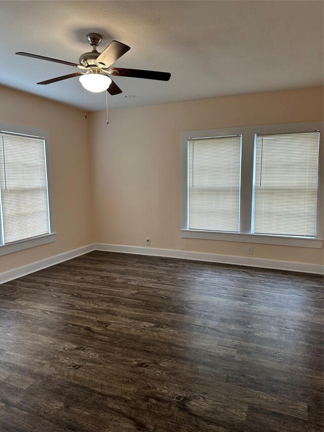 living room featuring dark hardwood / wood-style flooring, ceiling fan, and a healthy amount of sunlight