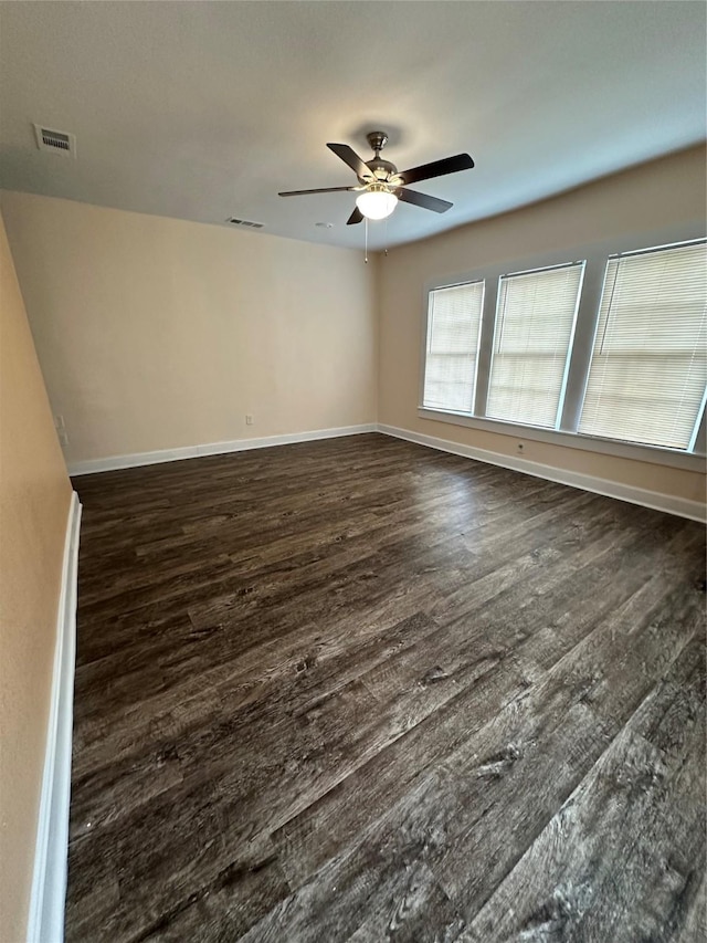 empty room with ceiling fan and dark hardwood / wood-style flooring