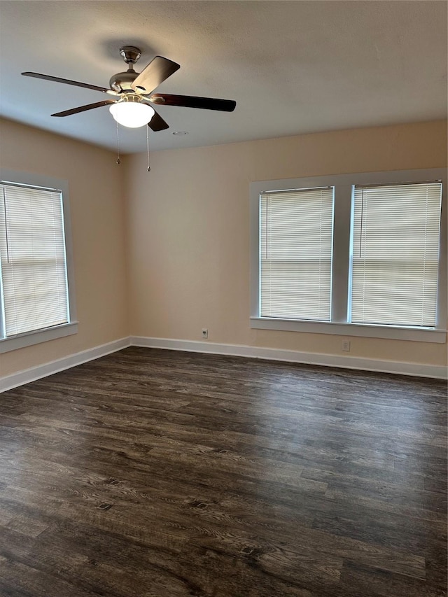 empty room with ceiling fan and dark hardwood / wood-style floors