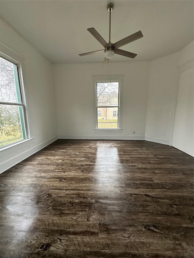 empty room with dark hardwood / wood-style flooring, plenty of natural light, and ceiling fan